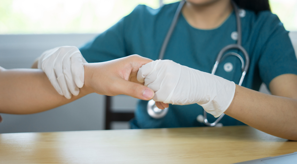 A doctor holding a patient's hand who is experiencing soft tissue trauma